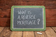 What is a reverse mortgage? A question written in white chalk on a slate blackboard, finance and retirement concept