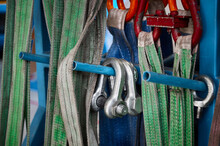 Rigging Equipment With Strops Hangs On Rack In Warehouse