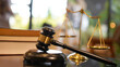 Lawyer or judge's hammer in the court. Auction's hammer is on woo table. Law subject or auction firm with book and golden judge's scale as symbol.