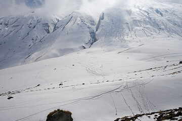 Local Nepali village among natural landscape view of snowcapped mountain cliff and cloudy blue sky- Nepal