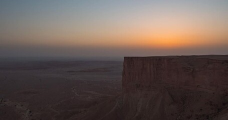 Wall Mural - Timelapse of the sun setting at Edge of the World escarpment tourist area near Riyadh, Saudi Arabia