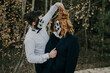© Julia Jones - A couple in love is standing in the woods celebrating Halloween in costumes and makeup and laughing
