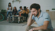 © silverkblack - Young student guy feels upset and isolated while his friends celebrating party at home