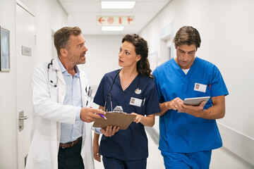 Wall Mural - Doctor and nurses discussing patient case at hospital