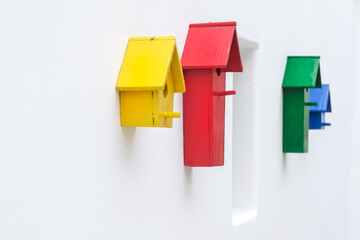 Colourful bird houses on a white wall in Santorini Greece