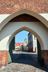 Canvas Print - Street and gate in a historic brick defensive wall in the city of Torun