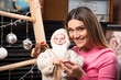 © rastockinc - Smiling woman in pink sweater holding a Santa Claus toy