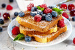 Summer breakfast with french toast. Baked with toasts with berries (blueberries, strawberries) and honey, traditional morning sweet dessert with fresh ripe berry