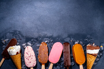 Wall Mural - Set of various ice cream popsicle on black background. Assortment of icecream cones and popsicles on dark background top view flatlay copy space