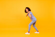 Full length profile portrait of positive excited person arms pull hold carry empty space isolated on yellow color background