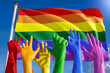 © Kyrylo Ryzhov - Rainbow colored hands from lgbt community over rainbow flag. World gay parade, concept of pride, freedom, elections, voting, rainbow flag, diversity. 3D rendering.