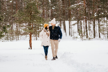 Poster - people, love and leisure concept - happy smiling couple walking in winter forest