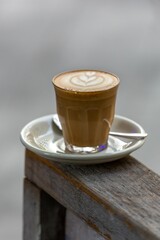 Sticker - Shallow focus of a cappuccino coffee glass cup with a heart-shaped design on the table