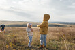© Andrii - A happy family with children flies a kite and spends time together outdoors in a nature reserve. Happy childhood and family holidays. Freedom and space.