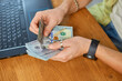 © bondarillia - Businessman hands counting cash american dollars banknotes