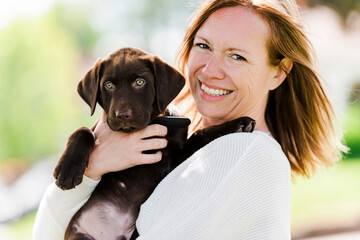 Nice Attractive young woman with baby labrador outdoors