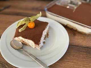 Sticker - Closeup of a slice of Tiramisu with a cherry on the plate.