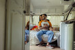 © LIGHTFIELD STUDIOS - happy gay man with long hair hugging joyful boyfriend on bed in modern van.