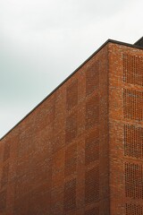 Sticker - Low angle of an old red brick building against a gray sky