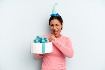 hispanic woman feeling happy and facing a challenge or celebrating. birthday cake concept