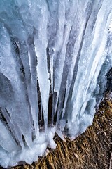 Sticker - Vertical closeup shot of icicles on a frozen waterfall