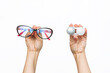 Cropped shot of a young woman holding container with contact lenses and stylish female glasses in her hands. The girl chooses what to wear to improve vision. Beauty, ophthalmology, eye protection