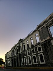 Canvas Print - Vertical shot of an old abandoned building under a sunset sky