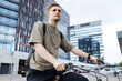 © Girts - Young man riding a bike. Sustainable micro mobility transport New way of inclusive cities mobility. Green transportation. Sustainable climate neutral city goals. Green mobility and transportation