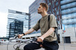 © Girts - Young man riding a bike. Sustainable micro mobility transport New way of inclusive cities mobility. Green transportation. Sustainable climate neutral city goals. Green mobility and transportation