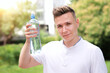© Евгений Шемякин - Portrait of handsome guy, young happy thirsty man runner is drinking pure fresh water from plastic bottle at warm sunny summer day outdoors after running, jogging, training outside. Side profile view
