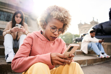 group of people ignoring each other using phone with serious face. latina woman focused on their mob