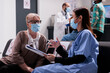 © DC Studio - Asian assistant consulting old woman in waiting room, talking about virus prevention and healthcare at hospital reception. Elderly patient and medical assistant chatting during covid 19 pandemic.