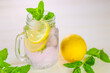 Lemon mint water with ice in a misted mug.Citrus cocktail with mint leaves. Sassy lemon water.Dietary lemon drink. ice falls into a glass with a cocktail.Sprig of mint in a glass with a cocktail.