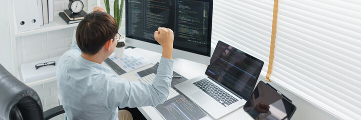 software development concept, male programmer excited and raise arms after successful programming