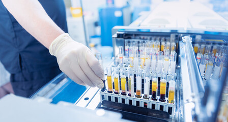 Wall Mural - medical scientist loading samples in robot machine for biochemical automatic testing blood laborator