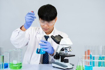 young attractive asian scientist working in chemical laboratory,doing chemistry experiments with microscope