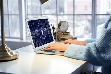 Wall Mural - Young woman using laptop with locked screen at table. Concept of online safety