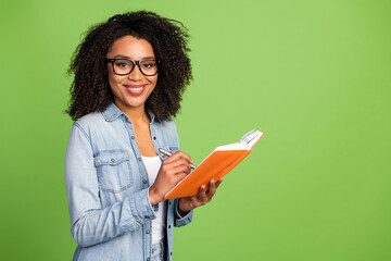 Wall Mural - Profile side photo of young cheerful woman good mood write notes manager isolated over green color background