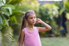 young aboriginal child with long hair in ponytail in garden