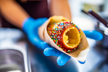 hand of chef baker making Trdlo or Trdelnik, Traditional tasty baked Czech Republic. street food