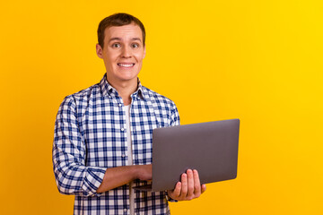 Photo of handsome satisfied young person hand hold netbook isolated on yellow bright color background