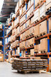 © Austockphoto - Cardboard boxes on pallets in warehouse shelving