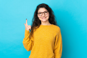 Wall Mural - Teenager Russian girl isolated on blue background pointing up a great idea