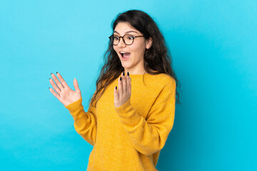 Wall Mural - Teenager Russian girl isolated on blue background with surprise facial expression