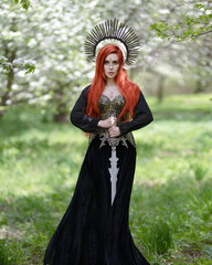 Art photo of a Valkyrie with a sword in a blooming apple orchard