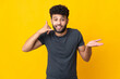 © luismolinero - Young Moroccan man isolated on yellow background making phone gesture and doubting