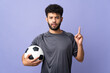 © luismolinero - Handsome Moroccan young football player man over isolated on purple background thinking an idea pointing the finger up