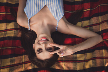 Poster - Top above high angle view portrait of attractive cheerful girl lying on fresh air spending free time showing v-sign relax outdoors