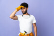 © luismolinero - Young electrician Moroccan man isolated on purple background doing surprise gesture while looking to the side