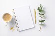© ActionGP - Business concept. Top view photo of workplace open notepad cup of coffee clips gold pen and eucalyptus sprig on isolated white background with blank space